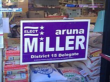 An image of a campaign sign for Aruna Miller for Delegate in the window of a local grocery store