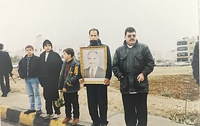 Mourners on Zahran street hold up portrait of King Hussein