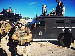 St. Charles County SWAT team at Ferguson. The device on top of the armored vehicle is a type of directed-energy weapon called an LRAD