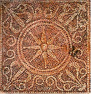 A red-orange mosaic displaying patterns and a central motif of a star-like symbol