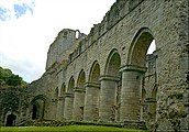 Exterior view of the nave from the north west, showing the massive round-section columns and a doorway into the north transept.