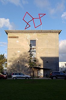 In the picture the rectangular silhoutte of the old air raid shelter called Bunker D can be seen with the red Cubus Balance sculptrure on its roof's middle.