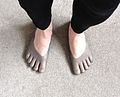 Five-toed shoes, transparent. It can be seen that the wearer's big toes are a bit too long for their pockets, and the small toes too short.