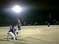 A metal-halide light bank at a softball field