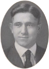 A young man facing camera wearing a suit coat and tie