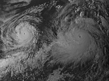 A satellite image of two powerful hurricanes over the Eastern Pacific. One is larger than the other, but both are very well-organized with tightly-wound circulations, clear eyes, and thick, deep clouds.