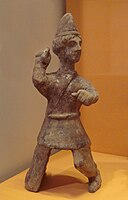 Mingqi (Chinese funerary statuette) of a young Central Asian man, with Saka-type caftan and conical hat reminiscent of early 3rd century AD Kushans. Later Han, 3rd century AD. Guimet Museum (MA 4660).[237]