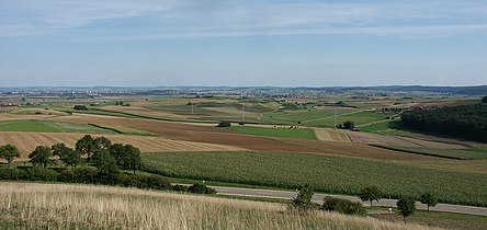 Blick ins Nördlinger Ries vom Blasenberg bei Kirchheim am Ries, links in der Ferne Nördlingen. Die bewaldeten Hügel am rechten Bildrand bilden den südlichen Kraterrand.