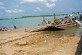 Bank of Oguta Lake showing human activities such as motorcycle washing and transportation of goods and people.