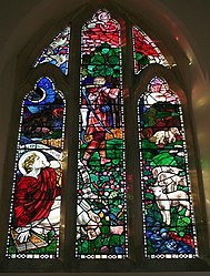 West Window, Hook Church: The "Good Shepherd" window by Henry Payne. A mix of a typical English country scene, with lambs and a stream, but with lions behind the wicker fence and a biblical king complete with what appears to be a zither.