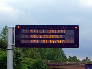 A three row fixed character matrix LED sign warns "Avoid London - Area Closed - Turn On Radio" following the 7 July 2005 London bombings