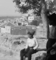 Two Lebanese village boys watching the sunrise. The boy sitting is wearing a labbadeh while the boy standing has on a tarboosh, c. 1920s