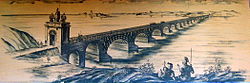 An artist's interpretation of Trajan's Bridge depicted upon a light brown surface, with bridge stretching from near shore of river on the bottom left and the far shore in the top right.