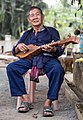 A Thai Lue musician plays in the garden of Wat Nong Bua, Tha Wang Pha District, Thailand.