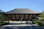 Wooden building with white walls built on a stone platform.