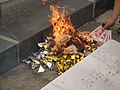 Paper yuanbao burned at a grave
