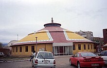 Yurt-shaped building with cars parked outside