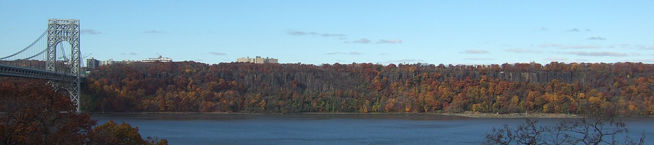 The Palisades, with fall foliage. On the left is the George Washington Bridge. A controversial plan to build a high-rise that would have broken the tree line was proposed, and later modified, by LG Electronics.[26]