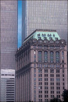 An Italianate building is seen at a 3/4 view, while the bottom half of the pre-2001 World Trade Center towers loom behind it