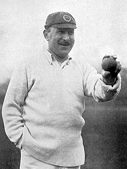 A black and white photograph of a cricketer holding a cricket ball