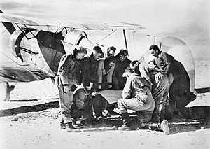 Ten men looking at a map on the tail unit of a Gladiator