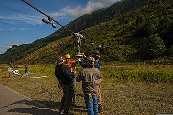 Contractors repairing one of the mile-long antenna wires that span the valley, which here is lowered to the ground for access.