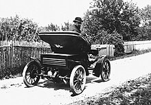 Ferdinand Budicki, automobile pioneer, seated in his car, ca. 1920s