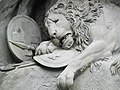 Löwenkopf mit Wappen und Waffen