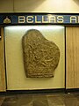 Replica of gravestone located in Metro Bellas Artes in Mexico City. The accompanying plaque translates to "Gravestone of Izapa – Mayan Culture – Preclassic Period – Description: Original is from Izapa, Chiapas. Represents a skeleton sitting with a (unreadable)."