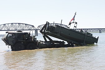 U.S. Army soldiers unload a Mk2 Bridge Erection Boat from a M1977A2 CBT HEMTT into the Missouri River