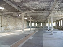 A large empty concrete hall with support pillars