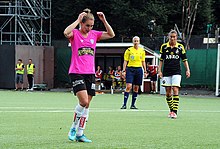 Woman in pink and black football kit