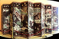 Coromandel lacquer screen with figures in pavilions and a main border with a "hundred antiques".