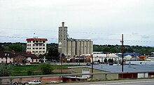 A multi-story building named the "Mill Inn" and tall grain elevator, seen from an elevated vantage point
