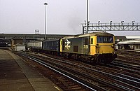 A British Rail Class 73 with a parcels van and carriages under British Rail carrying the mail in 1986 through Clapham Junction