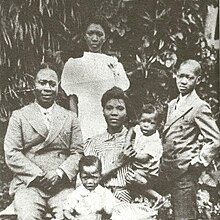 Image of Funmilayo Ransome-Kuti seated, with husband and children