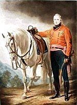 Painting shows an man in a red military uniform with black breeches standing next to a white horse.
