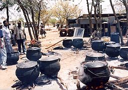 Three-legged iron pots being used to cater for a school-leavers' party in Botswana. Everyday cooking is done in the school kitchens.