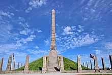 Haraldshaugen Monument is a stone column on a hill raging into the blue sky