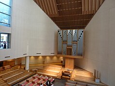 One of the rooms inside St. Peter's Church, which has wooden pews, a sloped ceiling, and angled walls