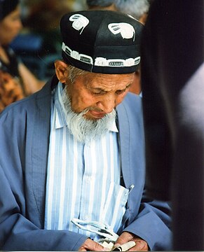 An Uzbek man wearing a doʻppi and a chopon
