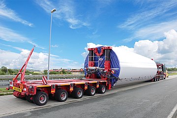 Windmill tower section being transported using tower adapter configuration