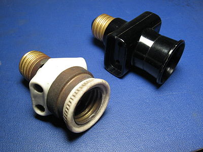 Italian bypass lampholder plugs with Edison screw mount. Left: early type (porcelain and brass, c. 1930). Right: late type (black plastic, c. 1970)
