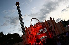 The park entrance at dusk, decorated for Halloween and illuminated by an ominous red light.