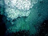 The white sulfur bubbles rise behind carbon dioxide bubbles