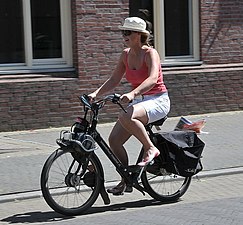 A woman riding a 2005 VéloSoleX Black'n Roll S4800 in France