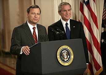 President George W. Bush looks on as his nominee for Chief Justice, John Roberts, speaks.