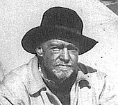 A black-and-white photograph of Shackleton staring into the camera