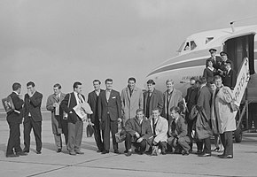 15 Spurs players posing for a photograph after disembarking from an aeroplane in Rotterdam, flight attendants and aeroplane in the background