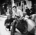 American officer and French partisan crouch behind an auto during a street fight in a French city. - NARA - 531322 - restored by Buidhe.png